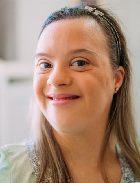 A special needs woman smiling while at home