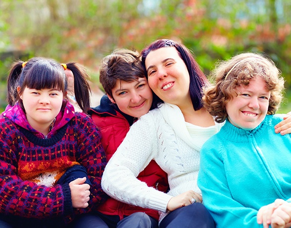 Four special needs dental patients smiling together