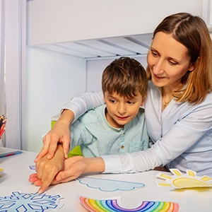 caregiver working with young boy with autism 