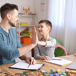 father high-fiving son with autism 