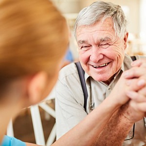 an older man smiling while visiting the dentist
