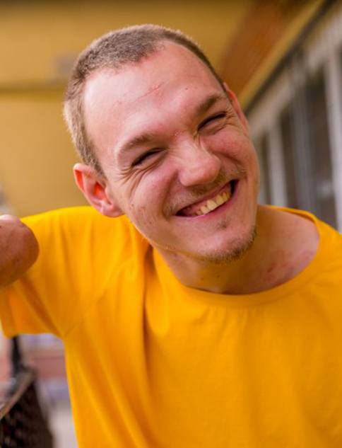 a man wearing a yellow shirt smiling