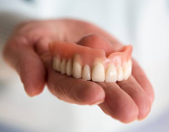 a person holding a full denture