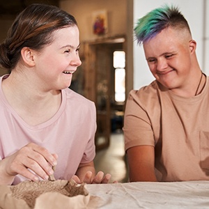 two people with Down syndrome making art together 