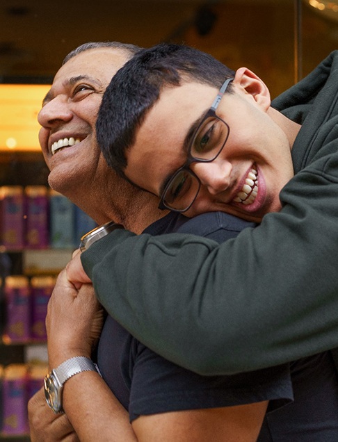 Special needs boy smiling and hugging his father