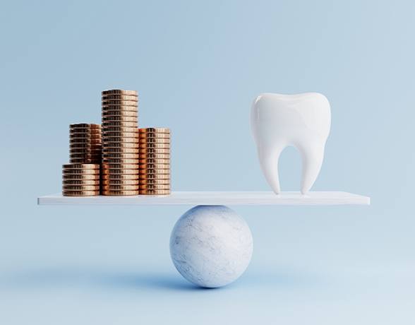 A model tooth and gold coins on a balancing scale against a blue background