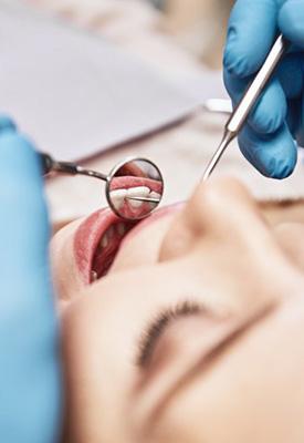 Close up of dentist inspecting a patient’s teeth