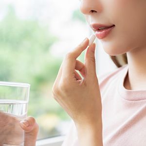 a woman taking an oral conscious sedation pill