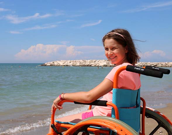 young girl with muscular dystrophy at the beach