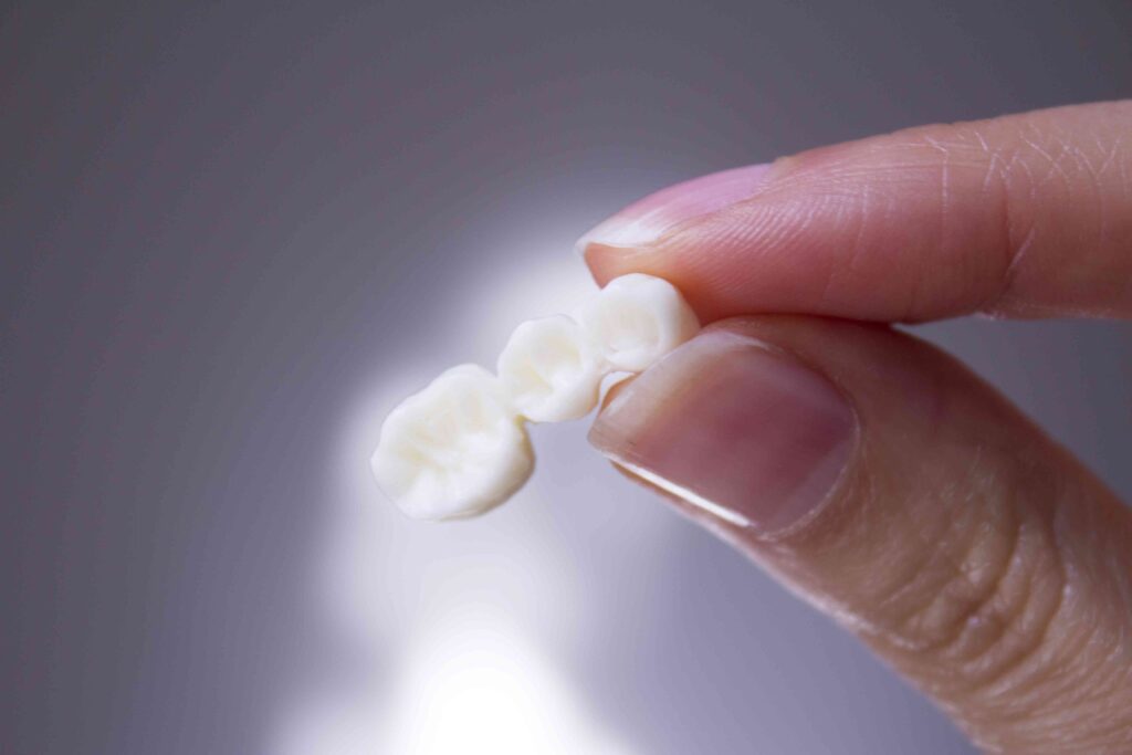 Person holding a dental crown