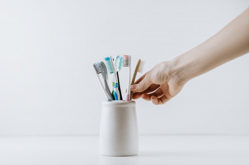Hand reaches for brush in holder